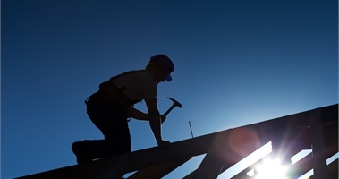 Bild på en arbetare som spikar på tak